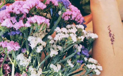 Tattooed hand holding flowers