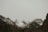a mountain range covered in snow and clouds