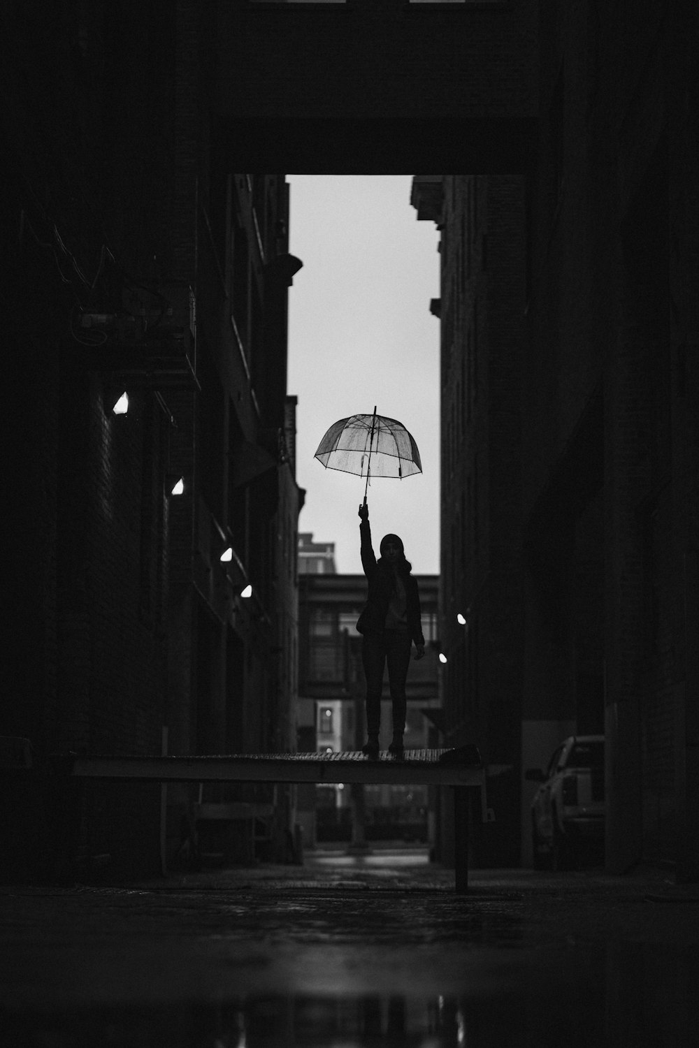 Eine Person, die einen Regenschirm in einer dunklen Gasse hält