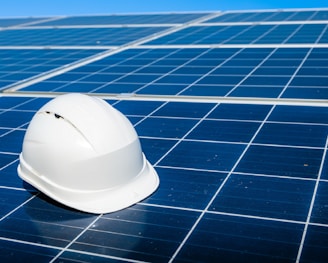 a white hard hat sitting on top of a solar panel