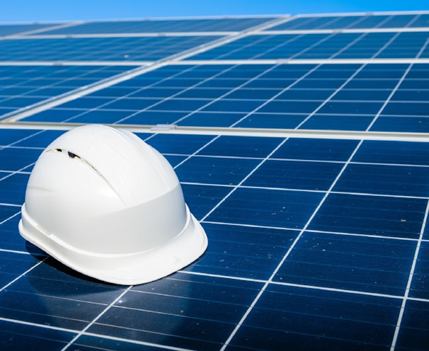 a white hard hat sitting on top of a solar panel