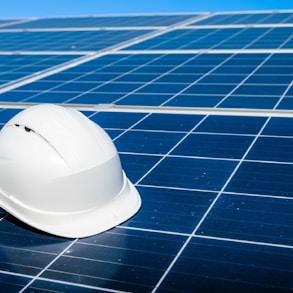 a white hard hat sitting on top of a solar panel