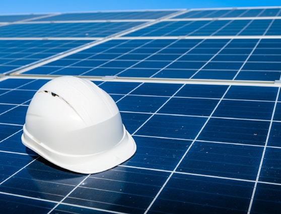 a white hard hat sitting on top of a solar panel