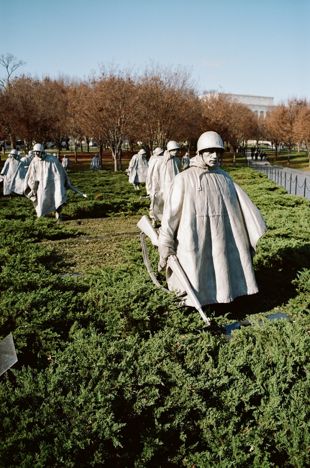 a group of statues of people in a field