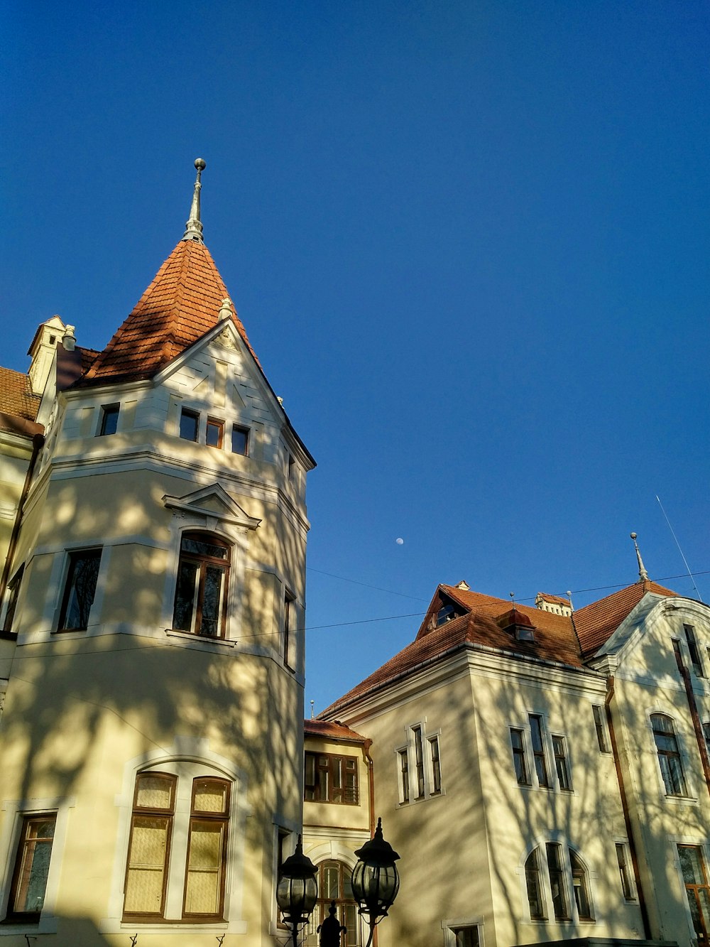 a tall white building with a red roof