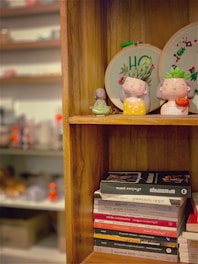 a book shelf with a couple of figurines on top of it