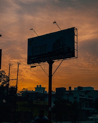 A vibrant billboard displaying an outdoor advertising campaign at sunset.