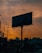 A vibrant photo of a freshly painted corporate logo on a large outdoor billboard at sunset.
