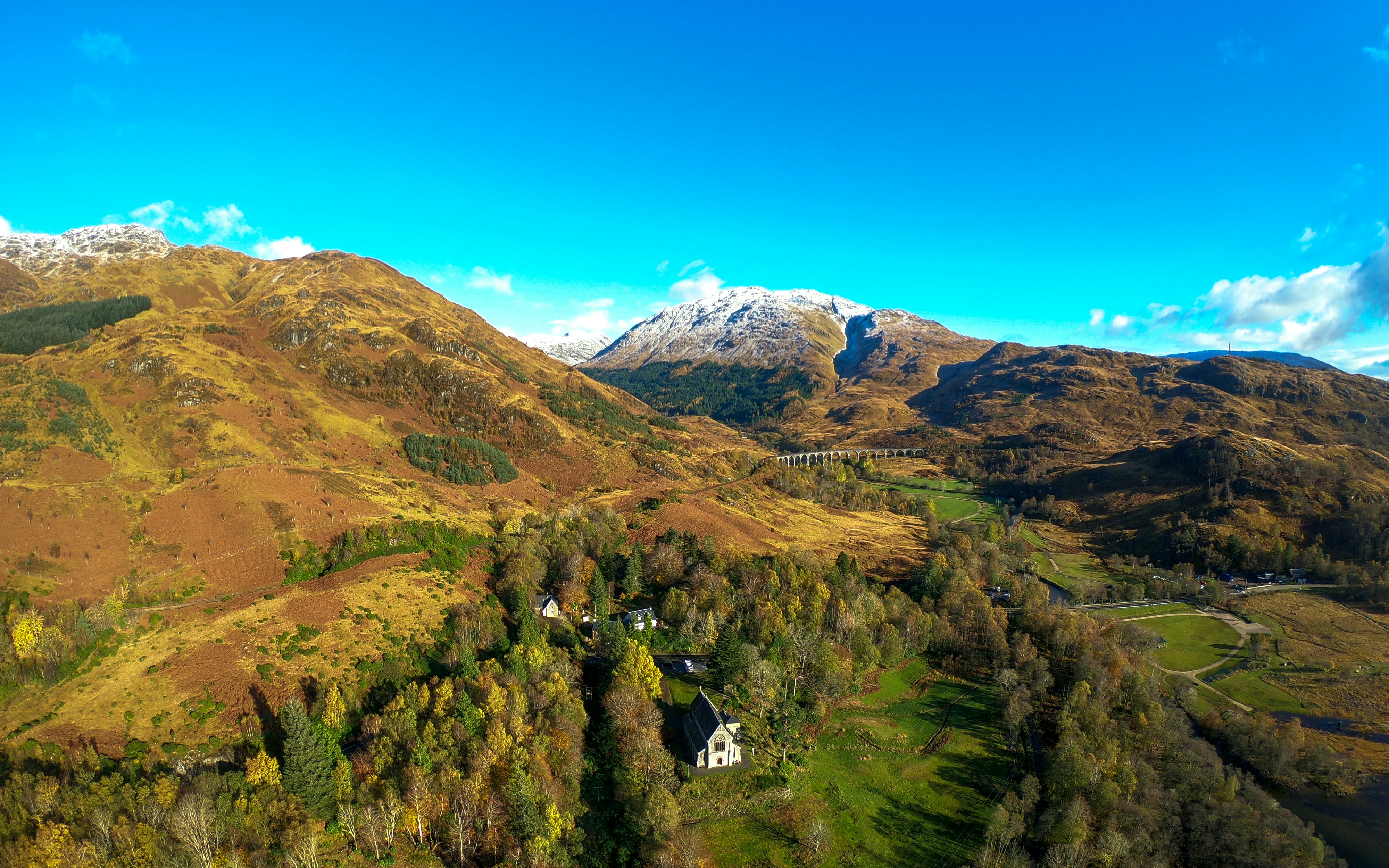 a scenic view of a mountain range with a river running through it