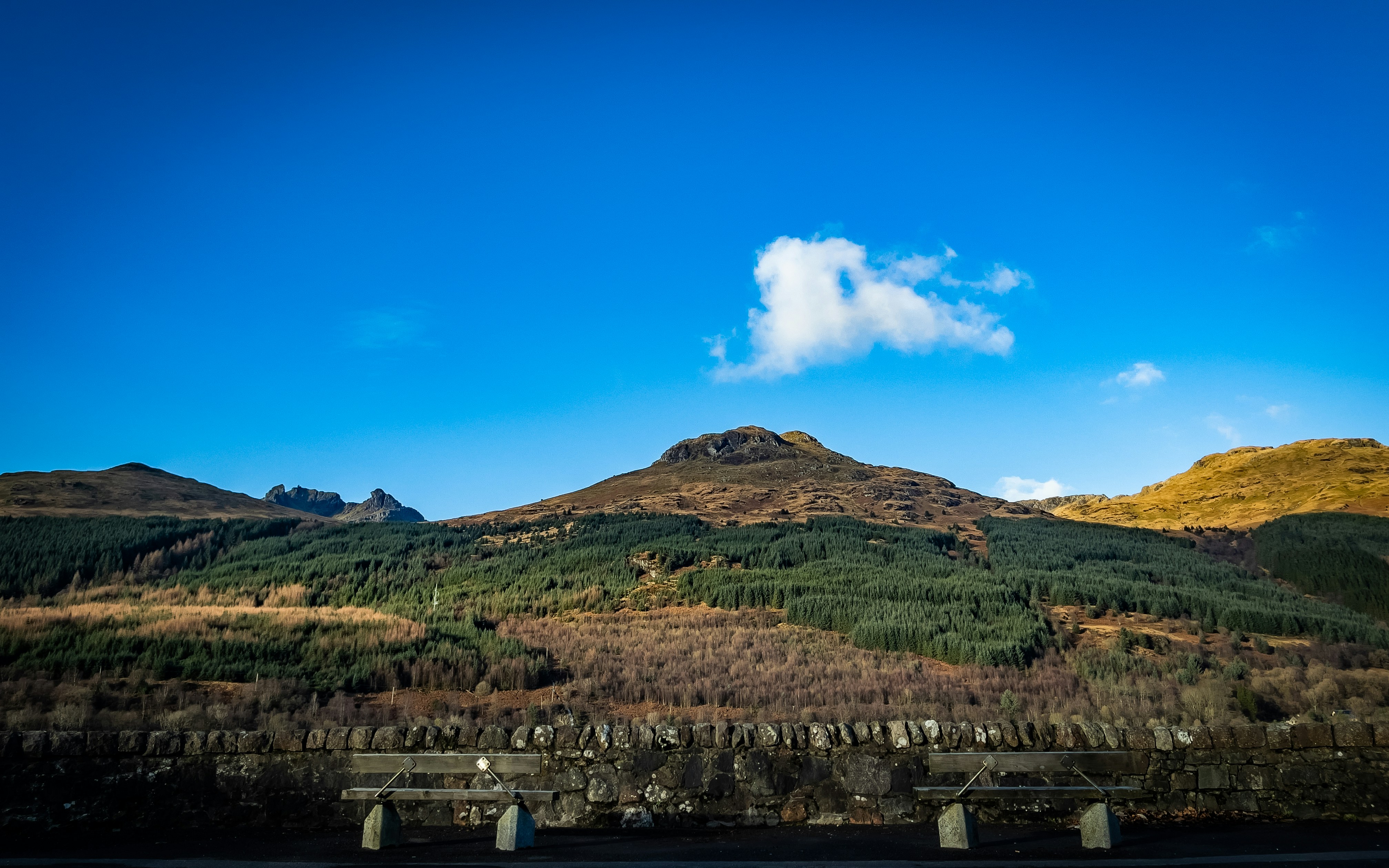 a scenic view of a mountain range with a bridge