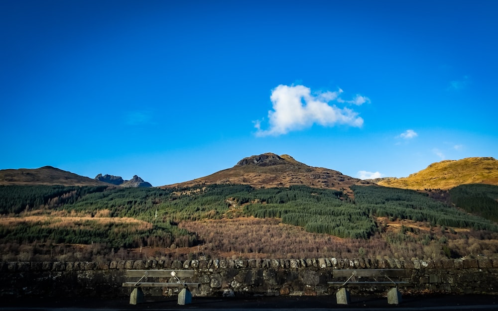 a scenic view of a mountain range with a bridge