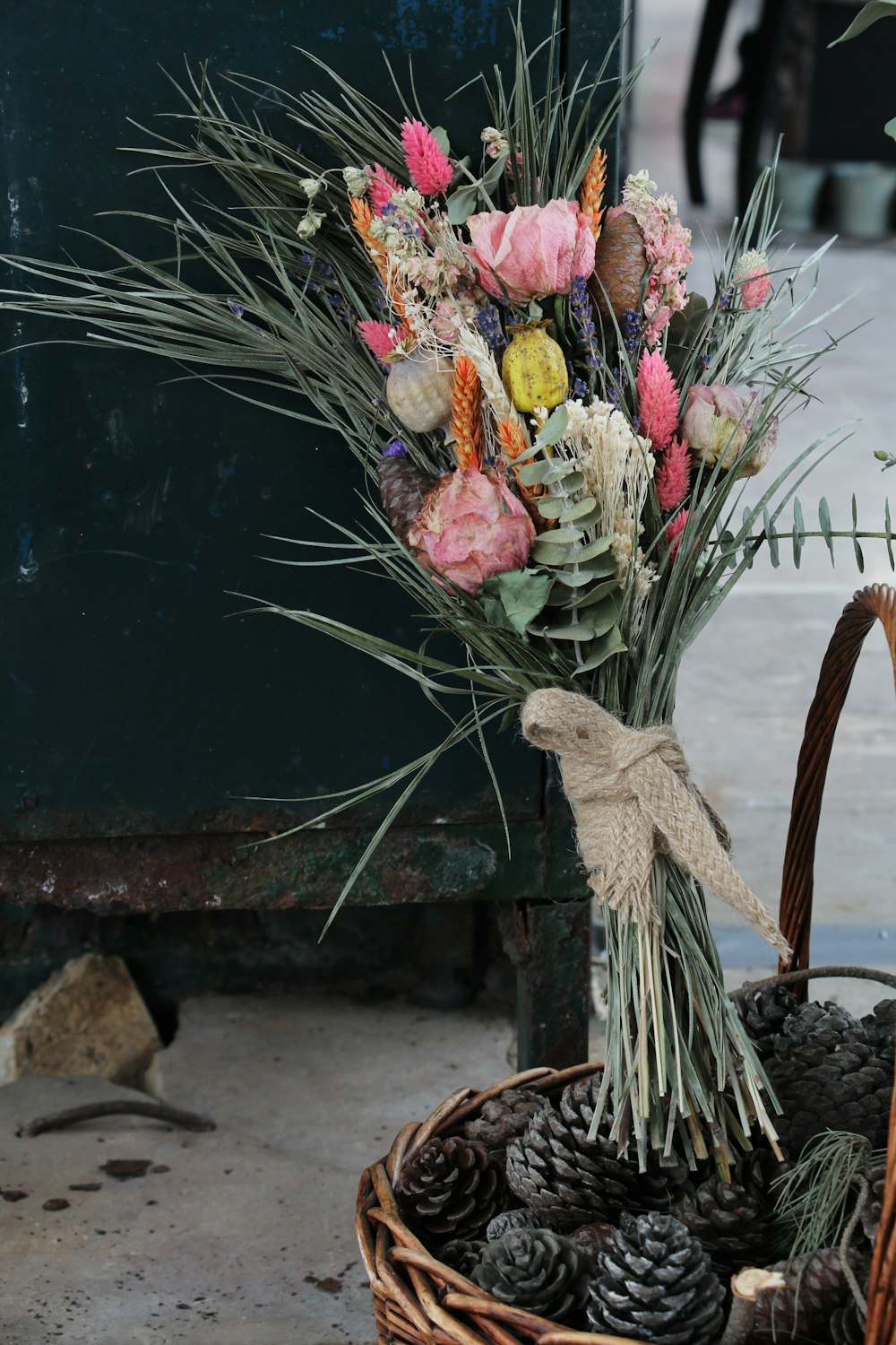 a basket filled with flowers and pine cones