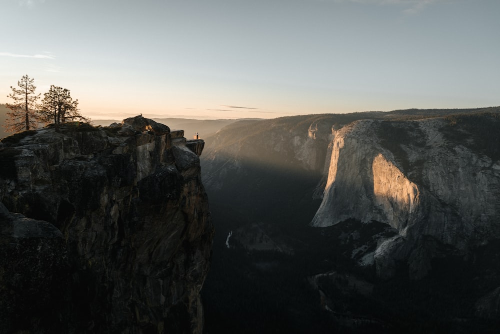 une personne debout au sommet d’une falaise