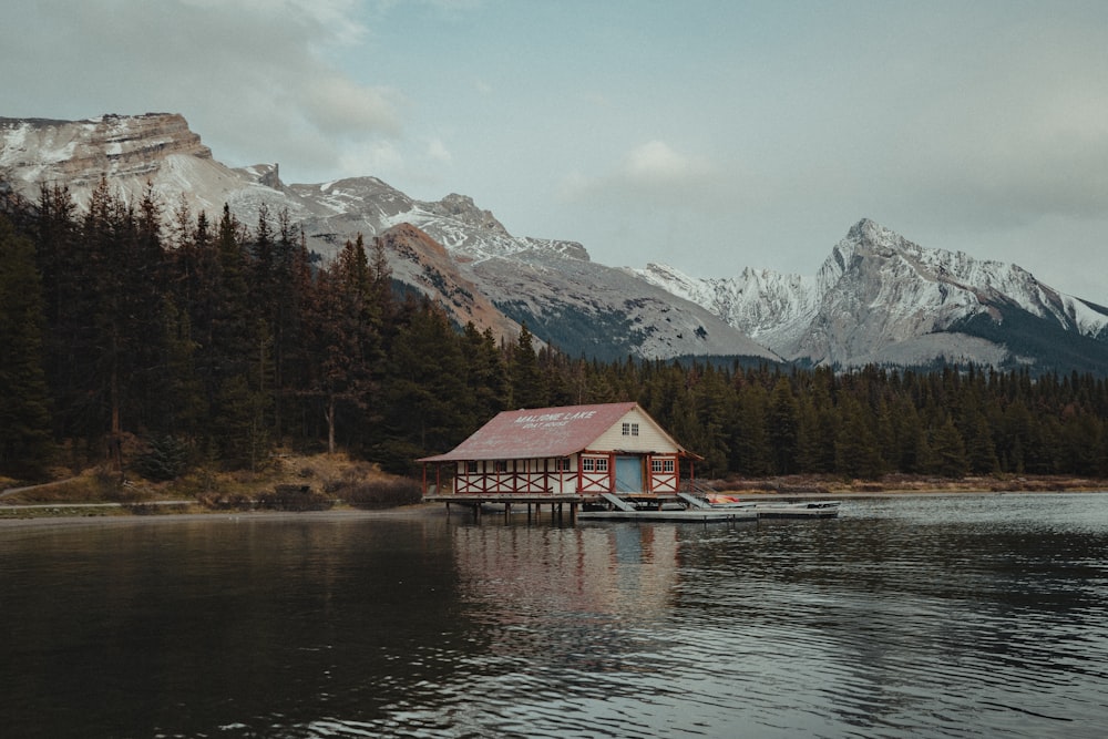 Una piccola casa su un lago con le montagne sullo sfondo