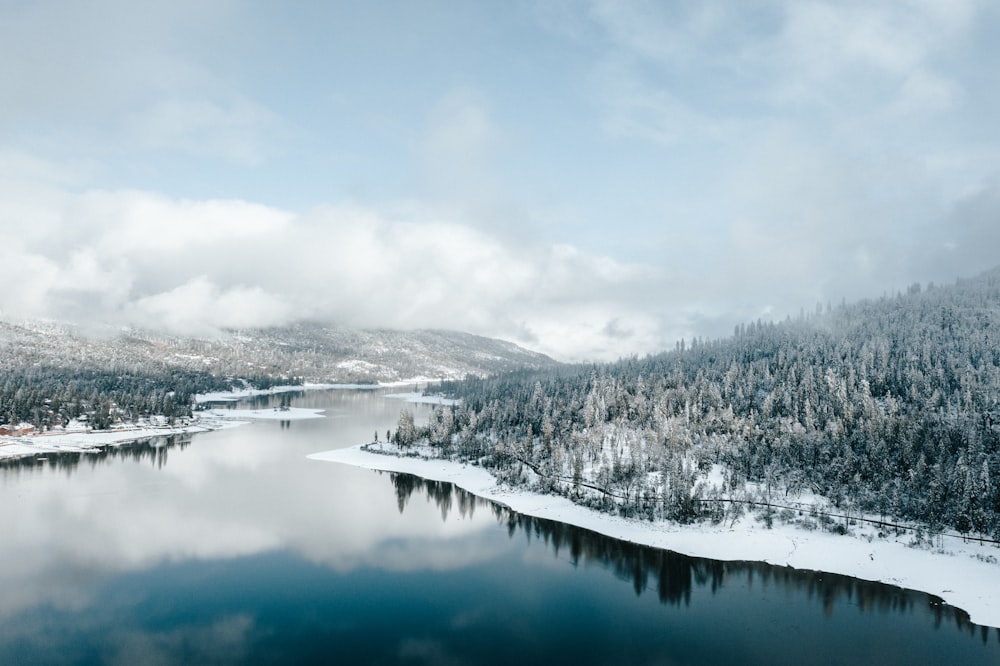 Un lago circondato da montagne e alberi innevati