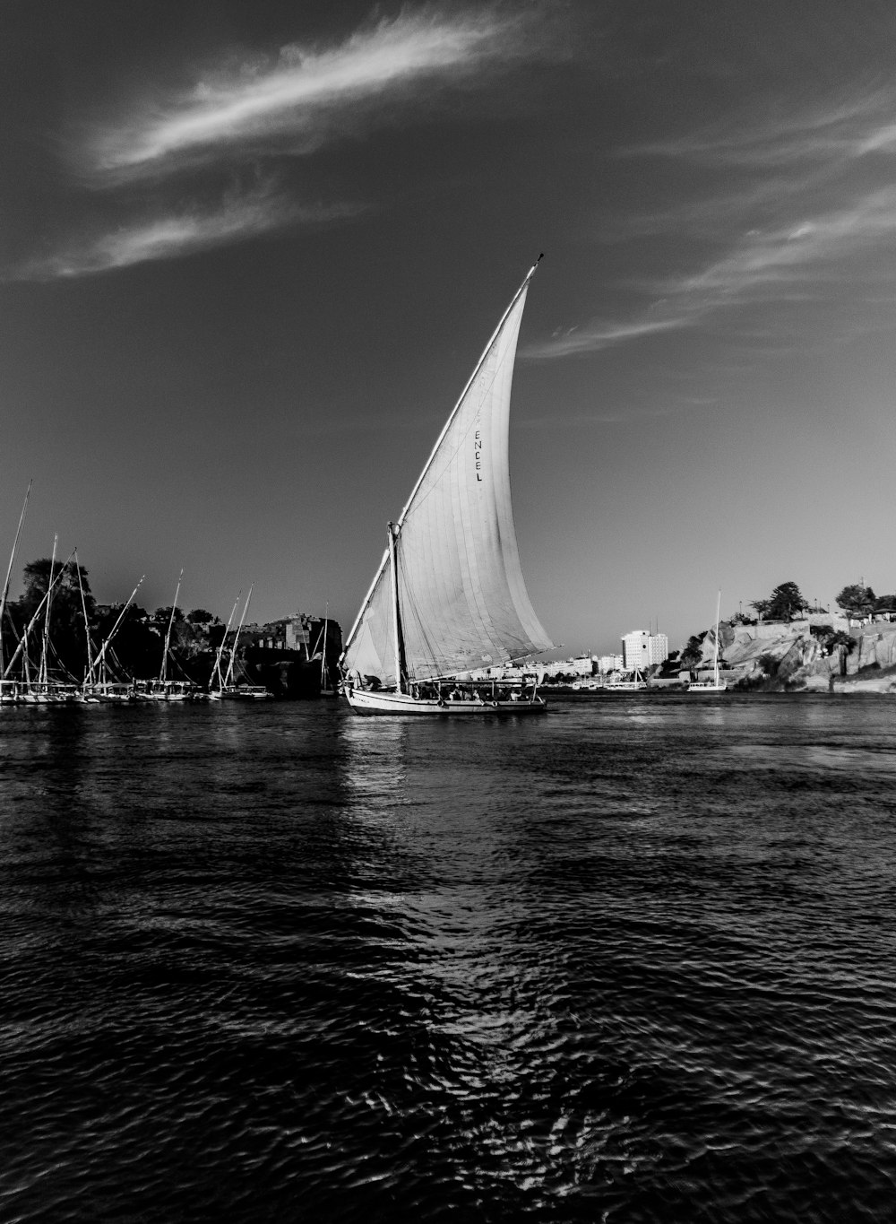 a black and white photo of a sailboat on the water