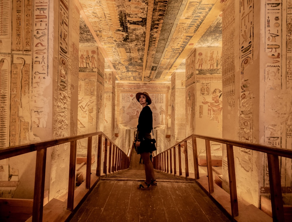 a woman standing on a bridge in an egyptian temple