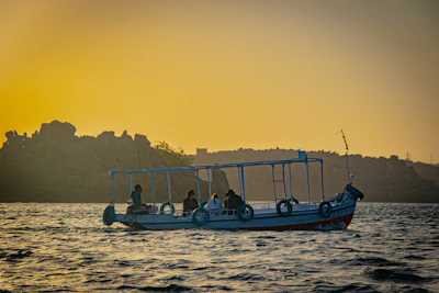A small group boarding a boat near a vibrant marina at sunset
