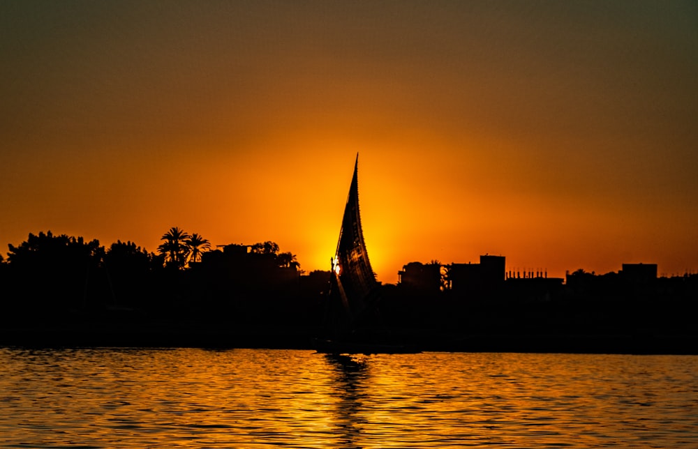 a sailboat in the water at sunset
