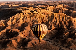 a hot air balloon flying over a desert landscape