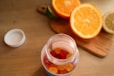 a jar filled with gummy bears next to sliced oranges