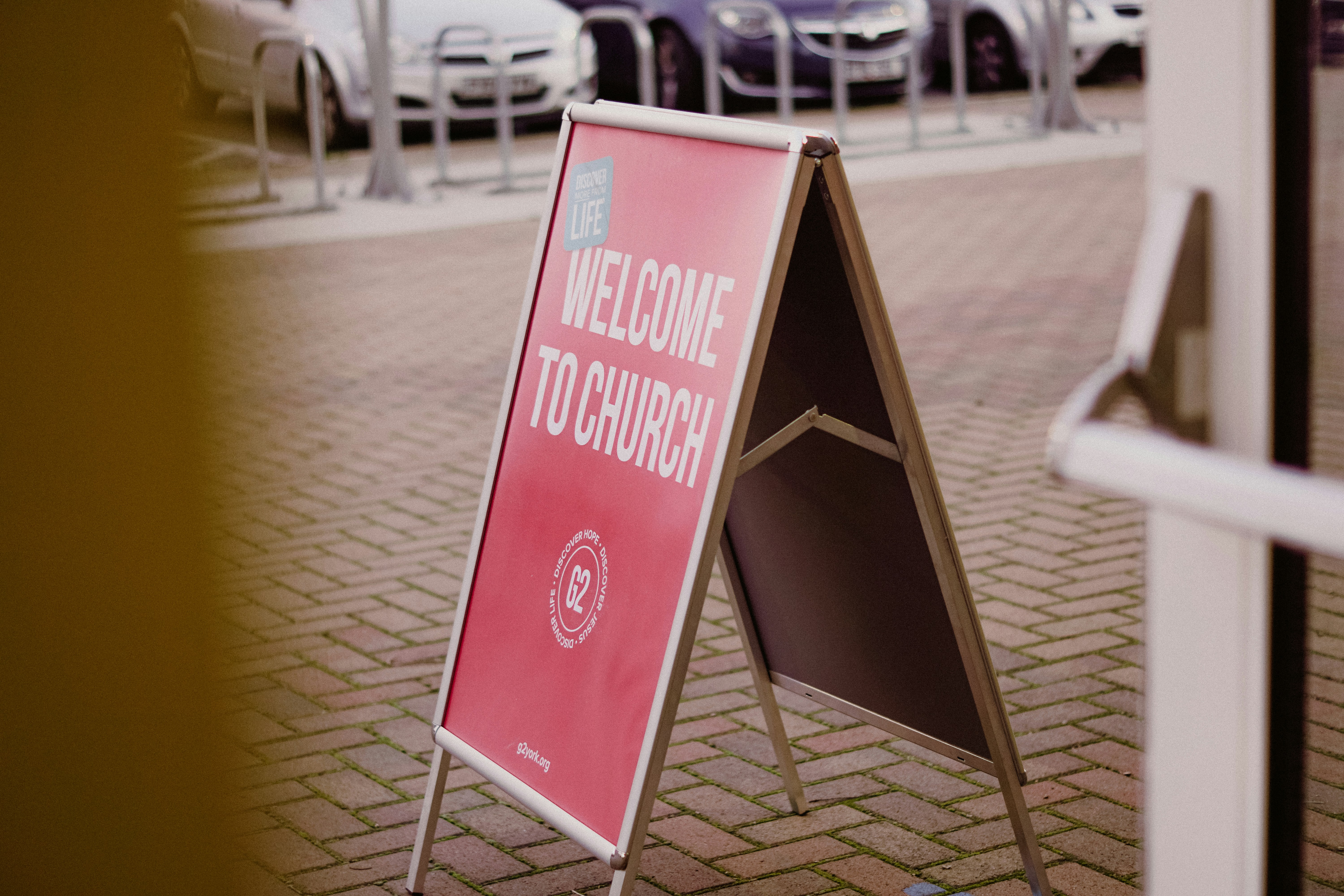 a welcome to church sign in front of a building