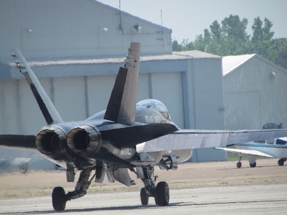 a fighter jet sitting on top of an airport tarmac