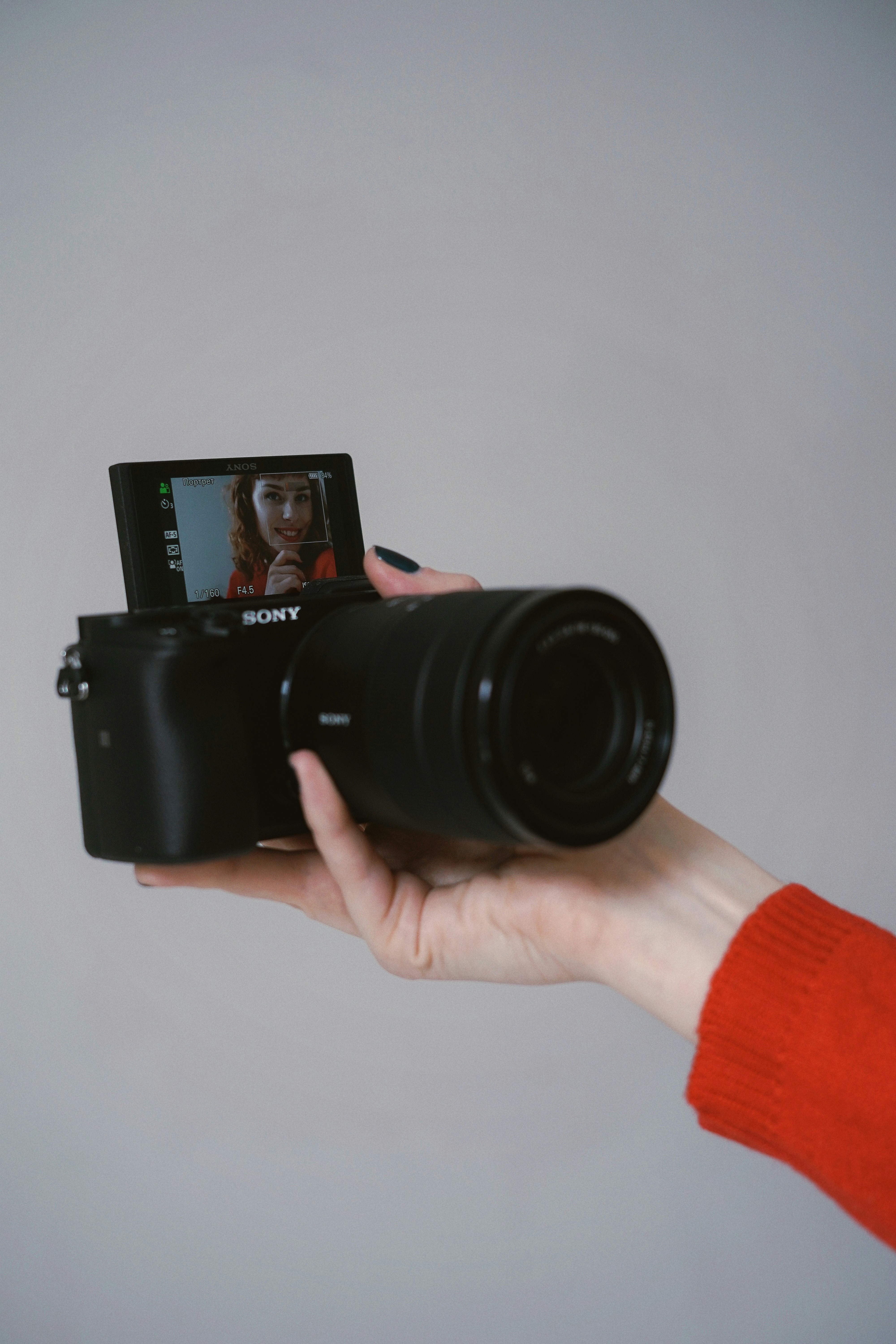 Eine Person, die eine Kamera hochhält, um ein Foto aufzunehmen