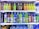 A refrigerator is filled with a variety of colorful bottled drinks. The top shelf displays fruit-flavored beverages with vibrant labels, including green, yellow, and orange colors. The middle shelf features sports and energy drinks in large plastic bottles with labels that use metallic and bright blue colors. The bottom section has a collection of water bottles and other cartons of beverages, showing a mix of branding and flavors.
