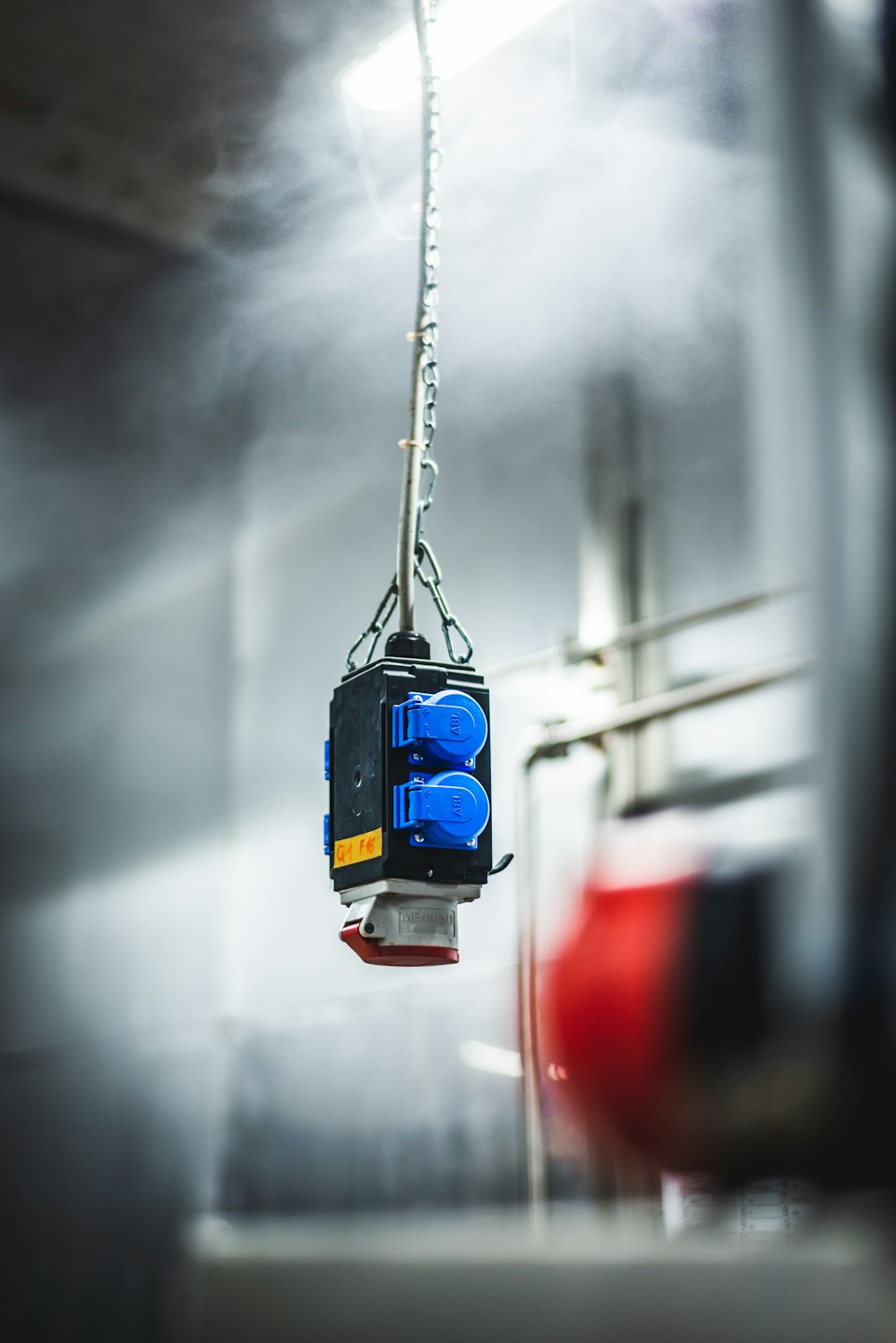 a blue and black object hanging from a wire