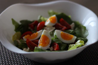A protein-rich salad with boiled eggs, spinach, walnuts, and a light vinaigrette in a rustic bowl.