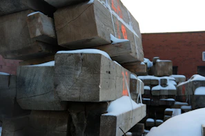 Large wooden beams being loaded onto a truck for delivery.