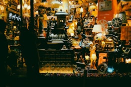 A display of quirky accessories and odd little gems arranged on a rustic table with warm lighting.