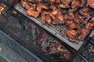 a bbq grill with chicken on top of it