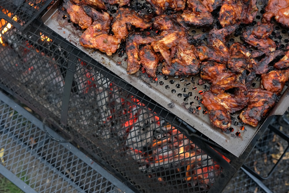 a bbq grill with chicken on top of it