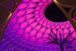 A sleek modern dome venue glowing warmly at sunset in Morocco.