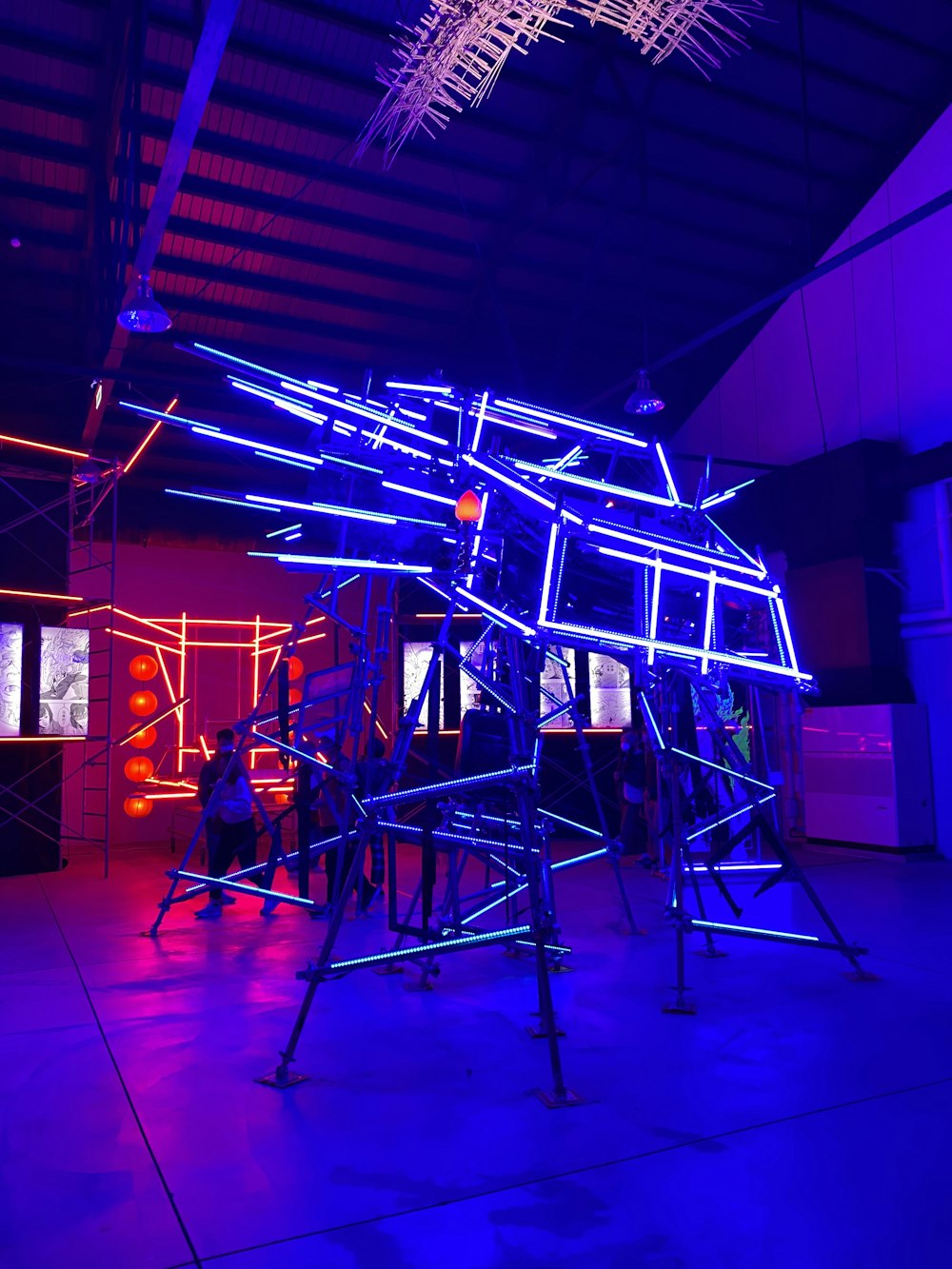 a group of people standing around a building with neon lights