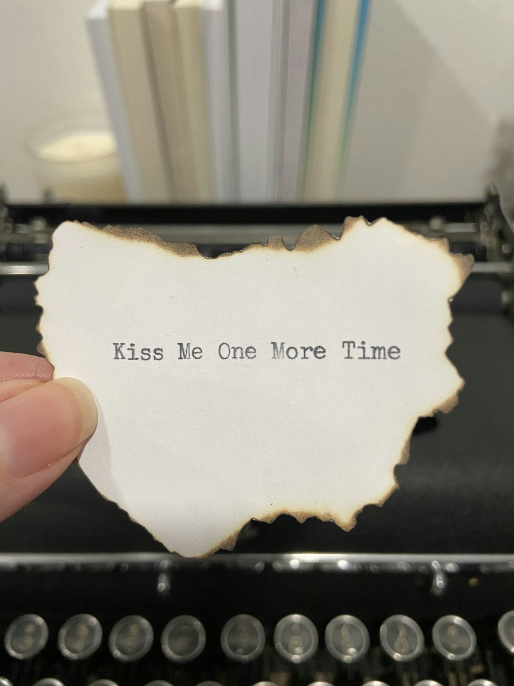 a hand holding a piece of paper that says kiss me one more time