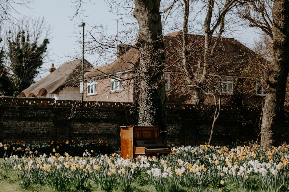 a wooden box sitting in the middle of a field of flowers