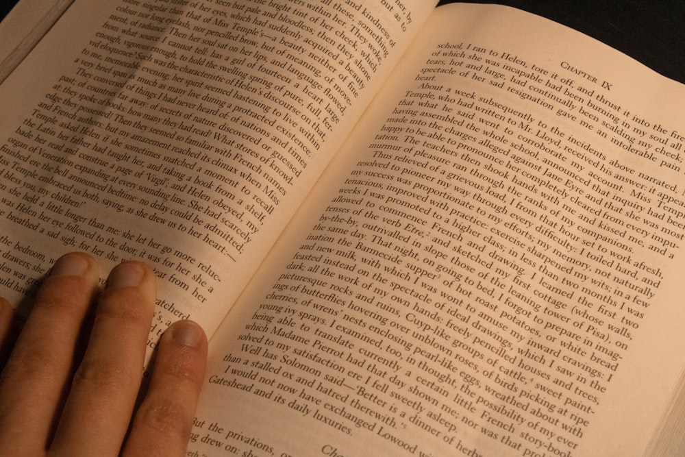 a person is reading a book on a table