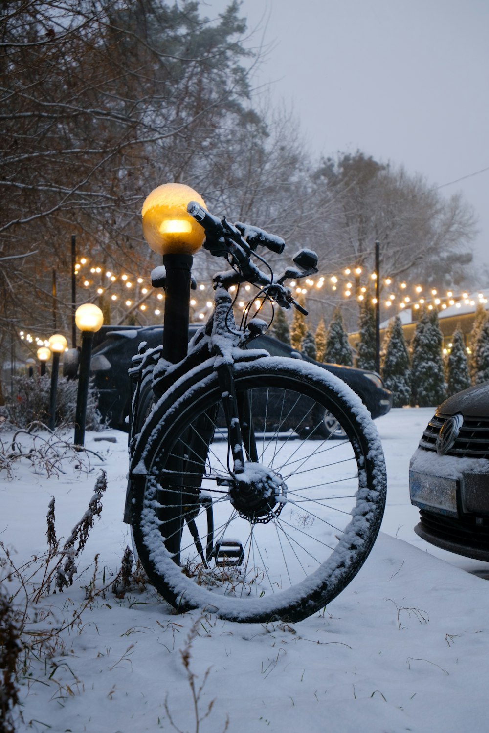 a bicycle parked in the snow next to a street light
