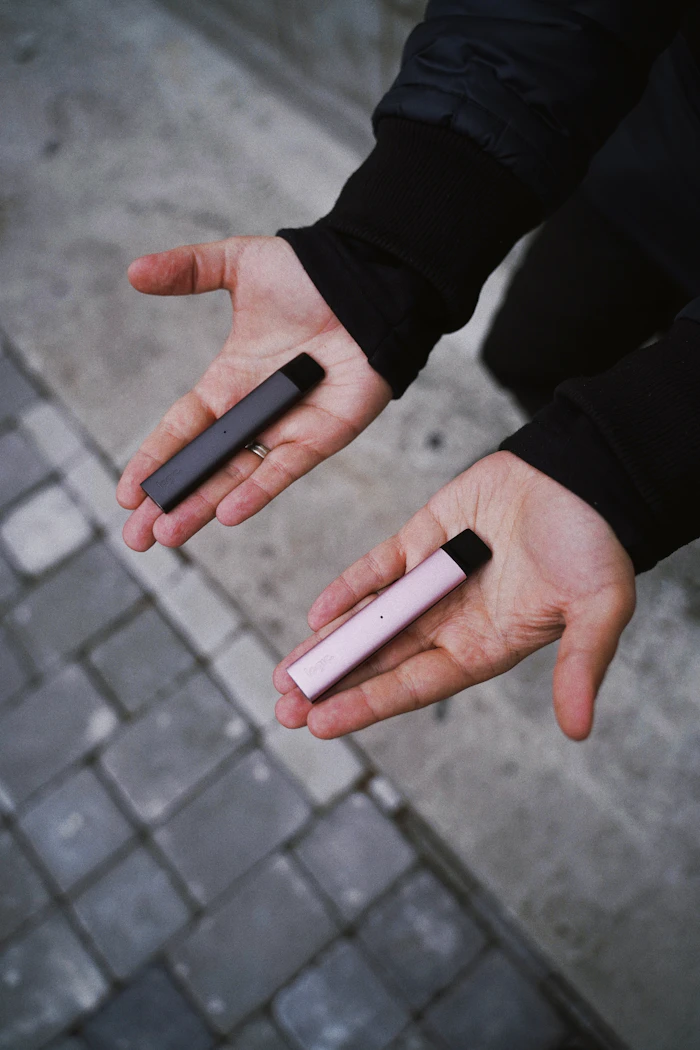 Person holding two pod devices in their hands