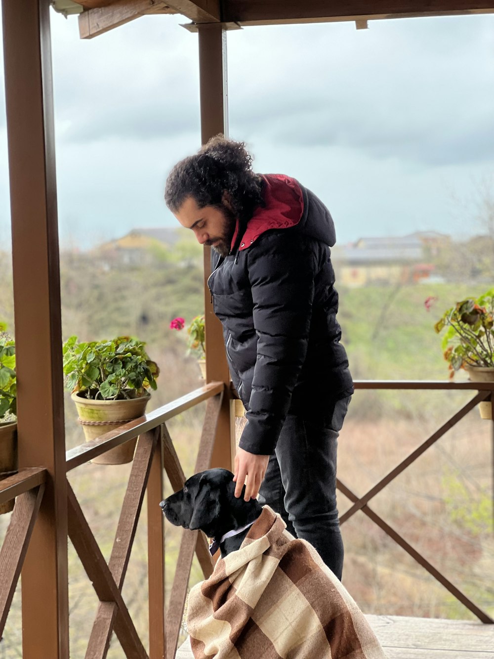 a woman standing on a porch next to a dog