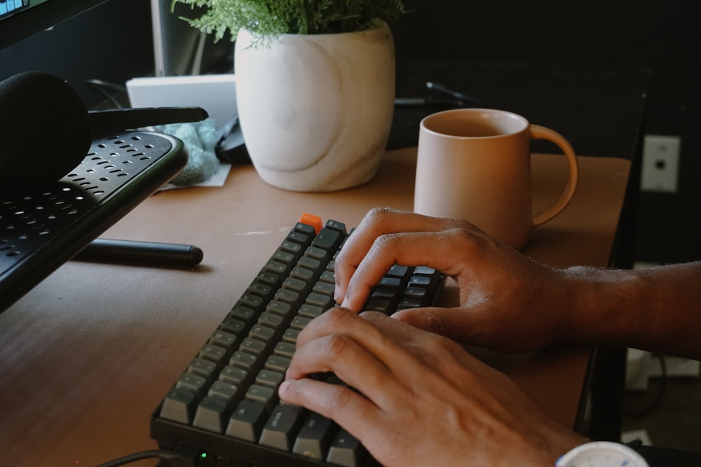 a person typing on a keyboard at a desk