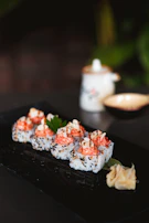 Golden Ginger's signature sushi rolls with a drizzle of spicy mayo and sprinkled sesame seeds on a rustic wooden board.