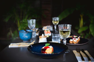 a table topped with plates of food and glasses of wine