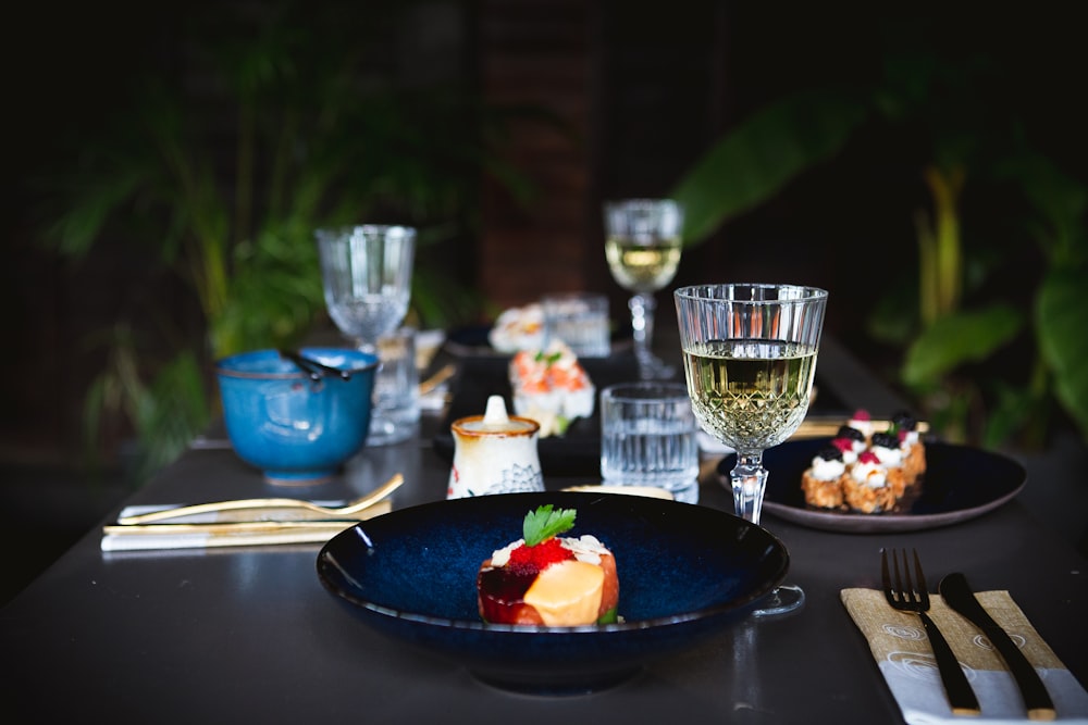 a table topped with plates of food and glasses of wine