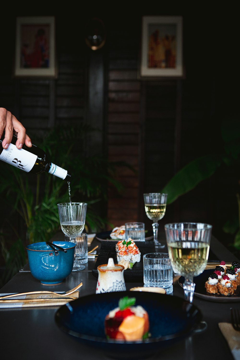 a person pouring wine into a glass on a table