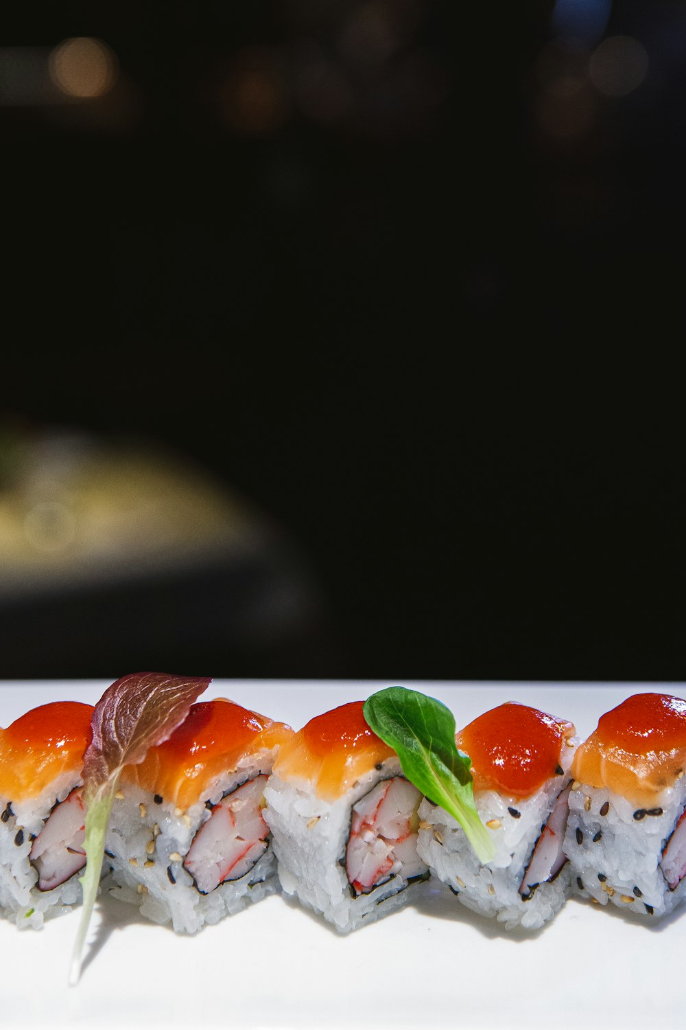 Un plato blanco cubierto con sushi cubierto de salsa