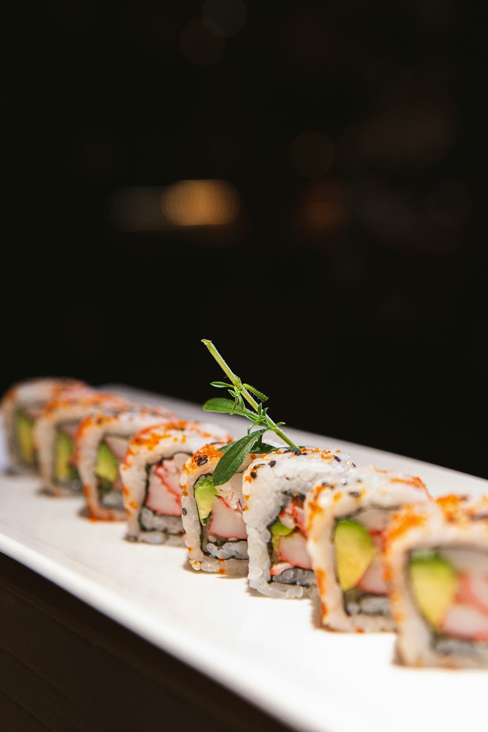 a white plate topped with sushi covered in sauce